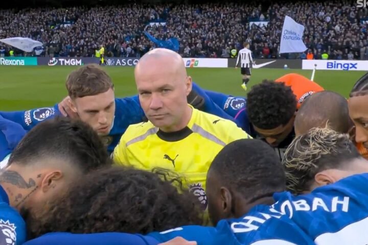 Chelsea team huddles around referee Paul Tierney ahead of Newcastle clash